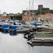 Vy över förtöjda båtar i Marstrands småbåtshamn med Carlstens Fästning i bakgrunden