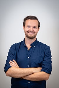 Jesper sommaren 2025 halvkropp leeende med armarna i kors.jpg